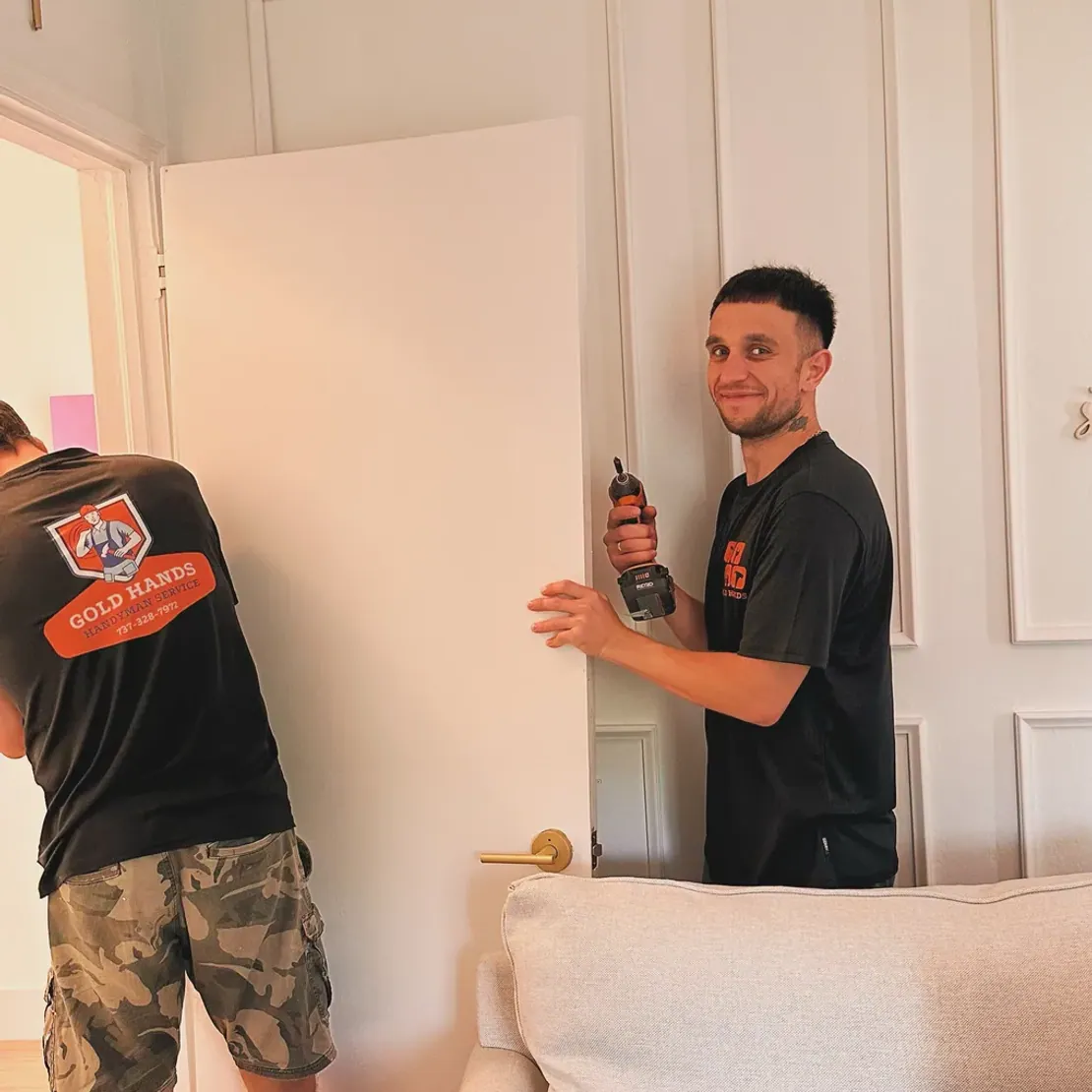 Two Gold Hands technicians hanging a door