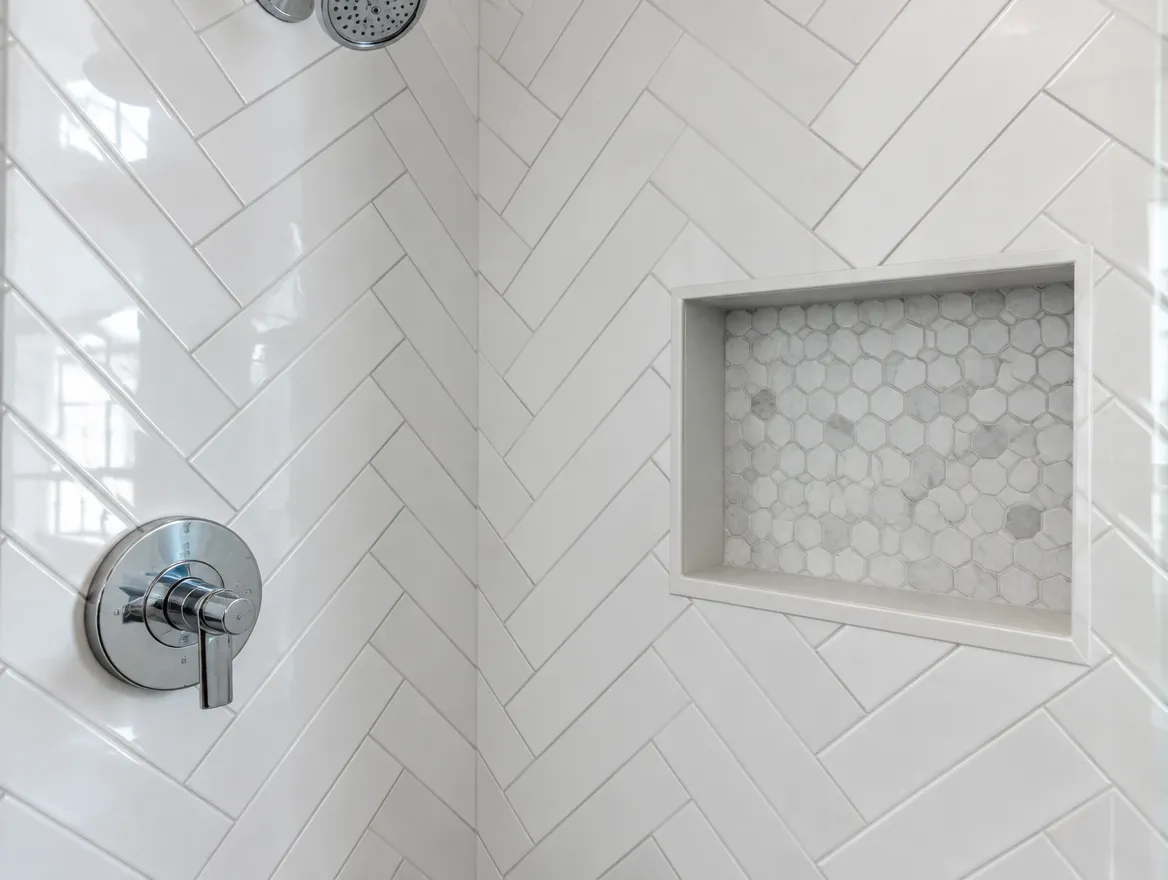 Illustration: shower wall finished in herringbone tile with a recessed niche