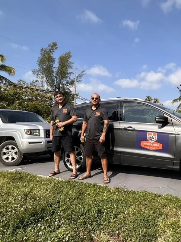 Gold Hands team next to the company cars