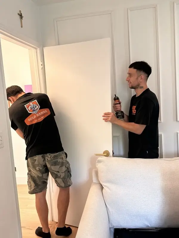 Two Gold Hands technicians installing an interior door
