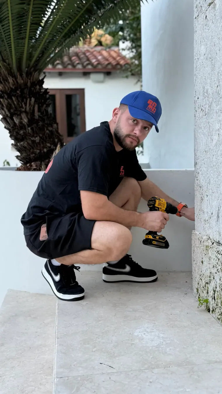 Technician drilling into an exterior wall