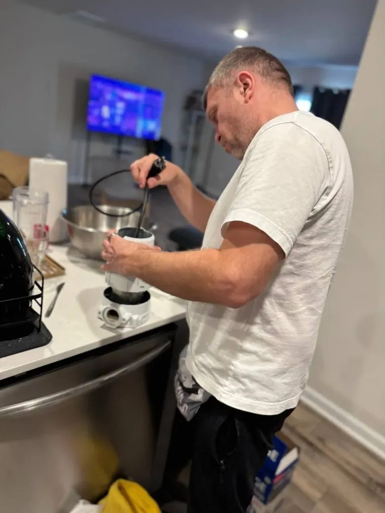 Technician installing a kitchen fixture